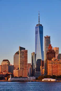 Image of View of new One World Observatory in New York City from off coast of southern Manhattan in golden hour sunset light