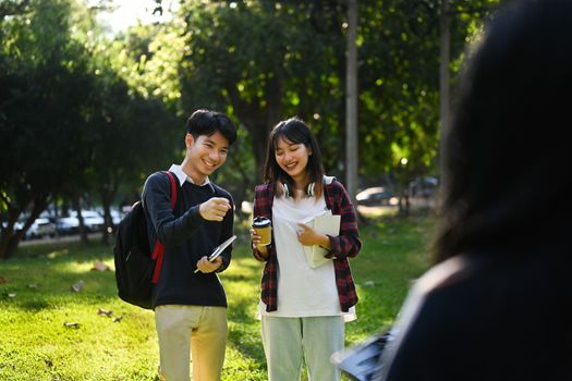 Happy university students talking about lessons while walking in university campus.