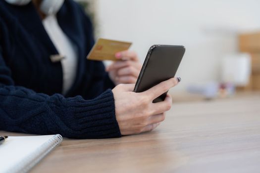 Young person using credit card and laptop computer. Online shopping, e-commerce concept.