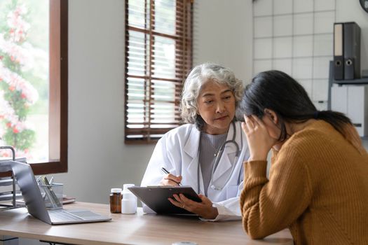 Senior doctor assisting a woman in her office. the patient is crying and feeling hopeless..