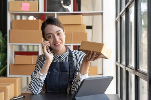 Small start-up business owners using computers and phones at work, salespeople, checking production orders. Pack products to ship to customers, sell ecommerce shipping ideas...