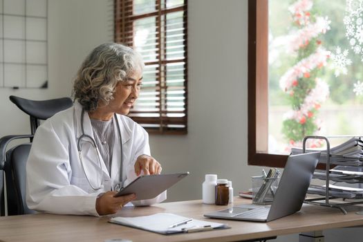 Asian senior doctor hospital medical medicine health care clinic office. using laptop computer...