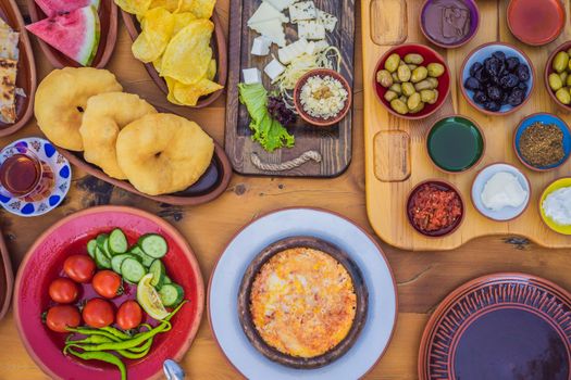 Turkish breakfast table. Pastries. Vegetables. Olives. Cheeses, fried eggs. Jams, tea in copper pot and tulip glasses. Wide composition.