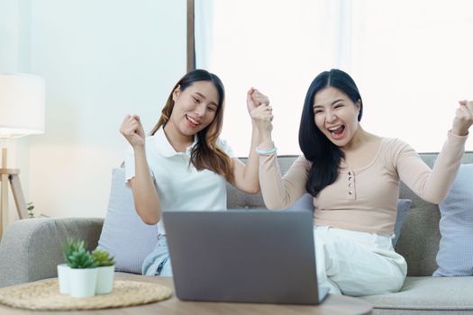 lgbtq, lgbt concept, homosexuality, portrait of two asian women posing happy together and loving each other while playing computer laptop on sofa.