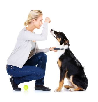 Hes such a good boy. Studio shot of a young woman with her dog isolated on white
