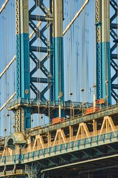 Image of Detail of beautiful Manhattan bridge section in sun with blue and white paint from Brooklyn