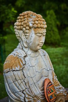 Image of Detail of cracks on ancient small Buddha statue for prayer and meditation