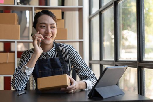 Small start-up business owners using computers and phones at work, salespeople, checking production orders. Pack products to ship to customers, sell ecommerce shipping ideas...