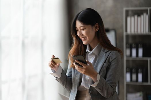 Young person using credit card and mobile phone. Online shopping, e-commerce concept.