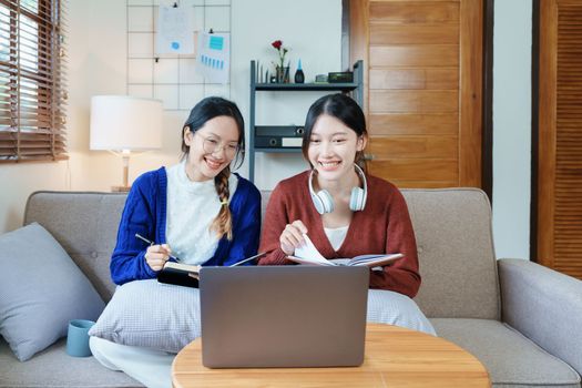 lgbtq, lgbt concept, homosexuality, portrait of two asian women posing happy together and loving each other while playing computer laptop with notebook for learning online.