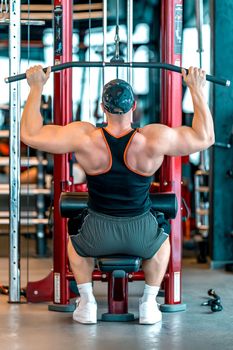 exercise of the back muscles by pulling the pulley on the strength machine. 