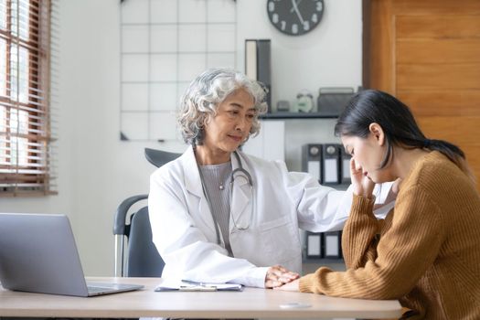 Senior doctor assisting a woman in her office. the patient is crying and feeling hopeless..