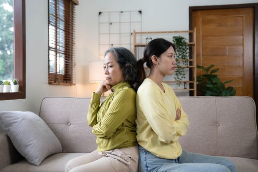 Family sit on couch having dispute, grown up daughter proves her right aggressively argue with elderly mother, 60s mom in despair due to misunderstanding. Generational gap, conflicts at home concept.