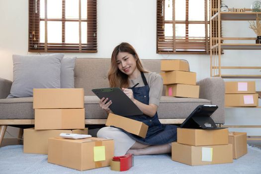 Portrait of Starting small businesses SME owners female entrepreneurs working on receipt box and check online orders to prepare to pack the boxes, sell to customers