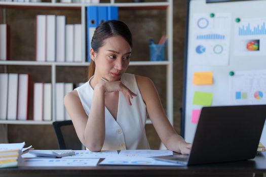 Asian Business woman working at home office and analyze financial report document. Accounting and Finance concept.