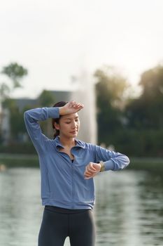 Healthy Asian woman is jogging outdoor. Fitness girl running. Female exercising at outdoor park.