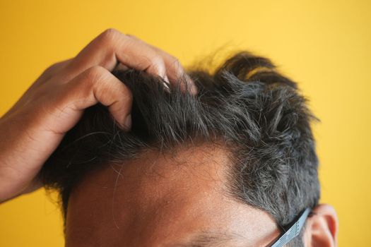 hair loss concept with man checking his hair .