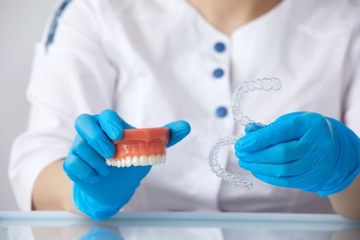 Orthodontist showing how the system of transparent aligners works on an artificial jaws
