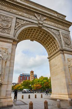 Image of New York City Washington Square Park limestone arch looking into fall park