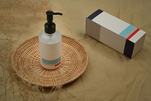 Shampoo or soap plastic bottle dispenser on wicker placemat. Natural skincare, beauty product design concept.