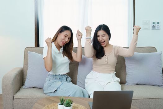 lgbtq, lgbt concept, homosexuality, portrait of two asian women posing happy together and loving each other while playing computer laptop on sofa.