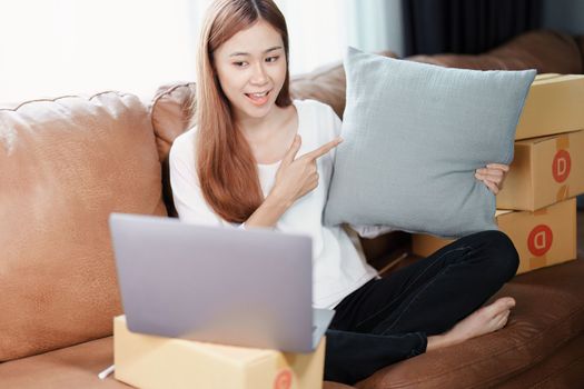 Starting small business entrepreneur of independent young Asian woman online seller using a computer showing products to a customer before making a purchase decision. SME delivery concept.