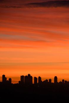 silhouette of residential buildings on sunset sky background.
