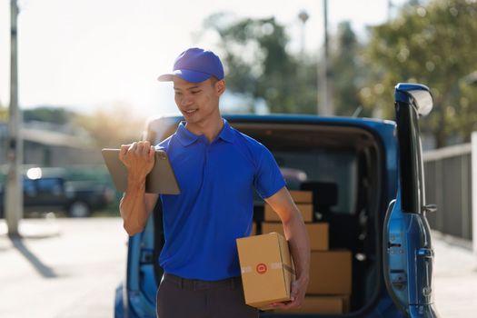 Asian courier with parcel and delivery logistic concept. Delivery man using digital tablet.