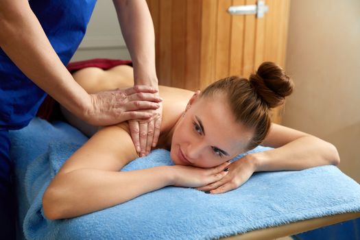 Young woman receiving massage in a spa salon