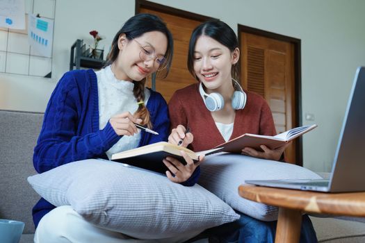 lgbtq, lgbt concept, homosexuality, portrait of two asian women posing happy together and loving each other while playing computer laptop with notebook for learning online.