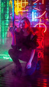 Caucasian woman with a gas mask in her hands in a neon studio