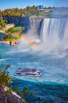 Image of Misty Niagara Falls with rainbow and tourist ship near Horseshoe Falls