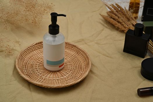 Blank white cosmetic bottle on rattan tray with natural cosmetics set on cotton silk fabric.