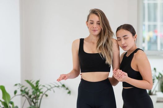 Caucasian woman stands on sadhu boards with therapist support