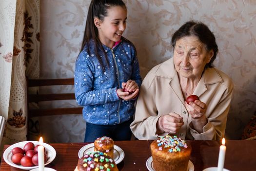 Easter cake in wrinkled hands of senior woman. Happy Easter concept, greeting card