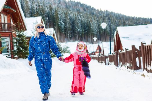 Winter, ski - Little girl with mother in ski resort