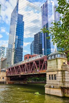 Image of Train for travel passing over bridge in Chicago canals by skyscrapers
