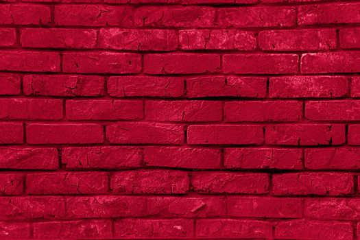 The texture of a red painted brick wall. Grunge background. Brick surface. Close-up background. Texture for the background.Viva Magenta Background color