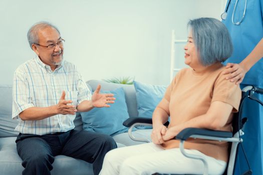 A contented senior couple and their in-home nurse. Elderly female in wheelchair with her young caregiver.