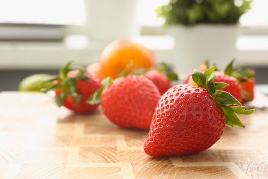 Fresh juicy strawberries and fruits on board. Vitamins and benefits of berries concept