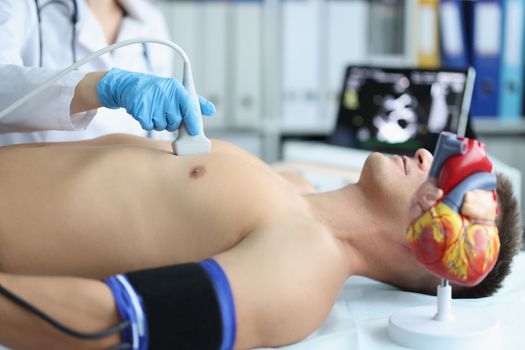 Man on ultrasound of heart in cardiology center. Diagnosis of cardiovascular diseases and treatment concept