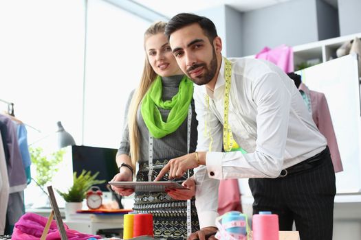Two young stylists of the designer communicate in atelier. Training in tailoring concept