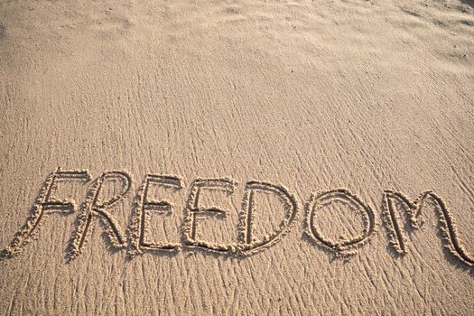 Freedom message written in the sand on the beach with copy spaceFreedom message written in the sand on the beach with copy space.