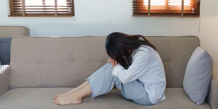 Young asian woman feeling miserable and lonely on sofa at home.