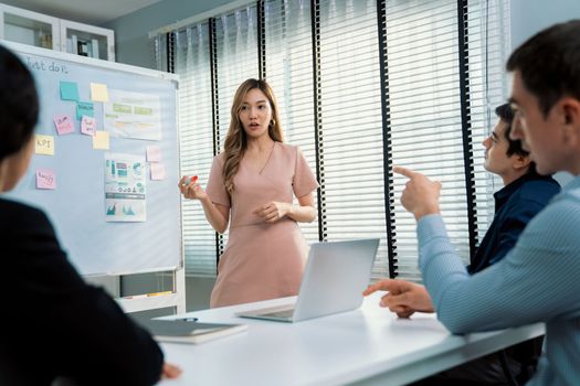 Competent office workers from various nationalities are debating, discussing and brainstorming in the meeting room. A group of employees is collaborating to achieve their business objectives.