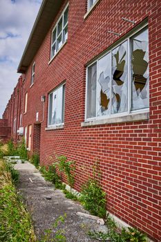 Image of Broken windows on exterior of abandoned brick hospital in midwest America