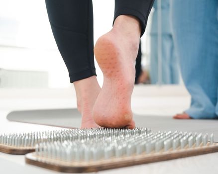 A woman comes down from the sadhu boards. Close-up of feet with prints after nails