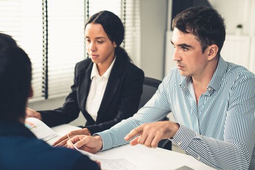 Competent office workers from various nationalities are debating, discussing and brainstorming in the meeting room. A group of employees is collaborating to achieve their business objectives.