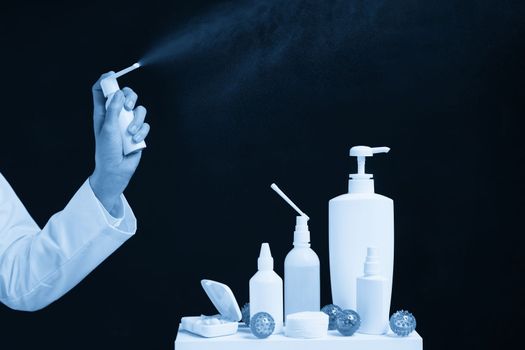 Doctor using spray sanitizer over black background