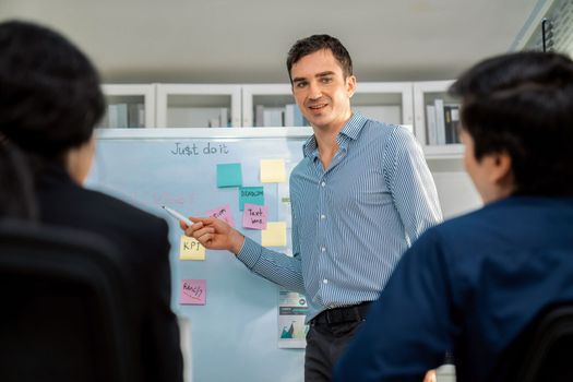 Competent office workers from various nationalities are debating, discussing and brainstorming in the meeting room. A group of employees is collaborating to achieve their business objectives.